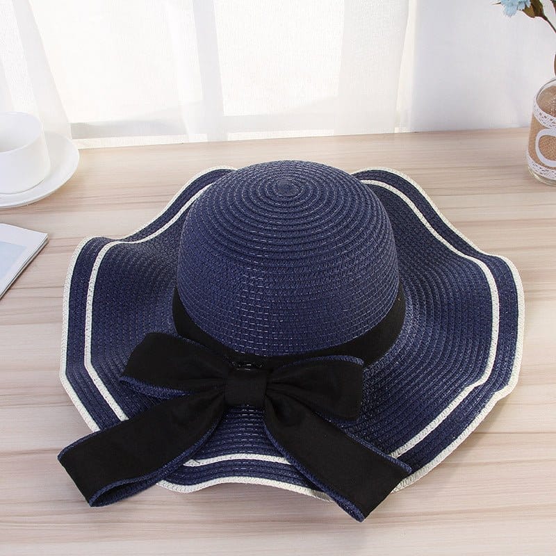 Stylish beach hats for women, navy blue straw hat with black bow, perfect for sun protection and summer outings.