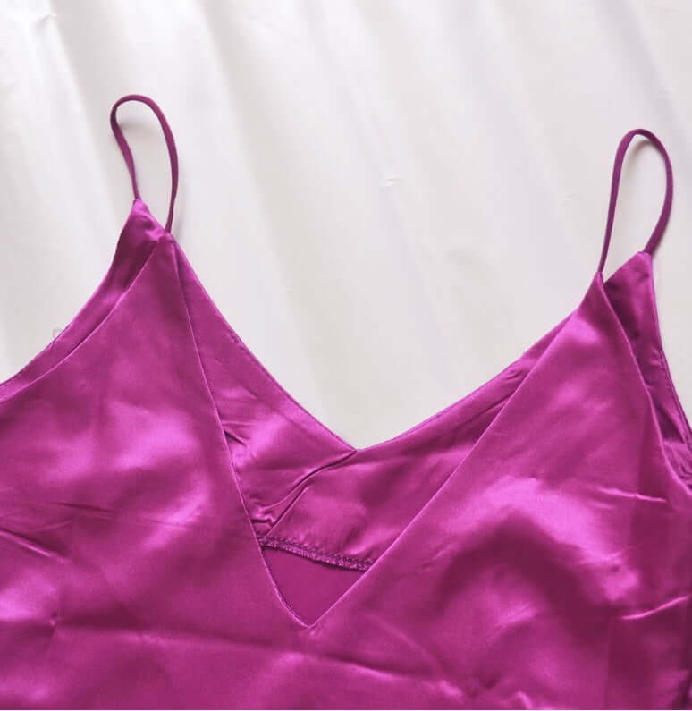 V-neck harness dress in bright purple satin fabric with delicate straps and a luxurious sheen.