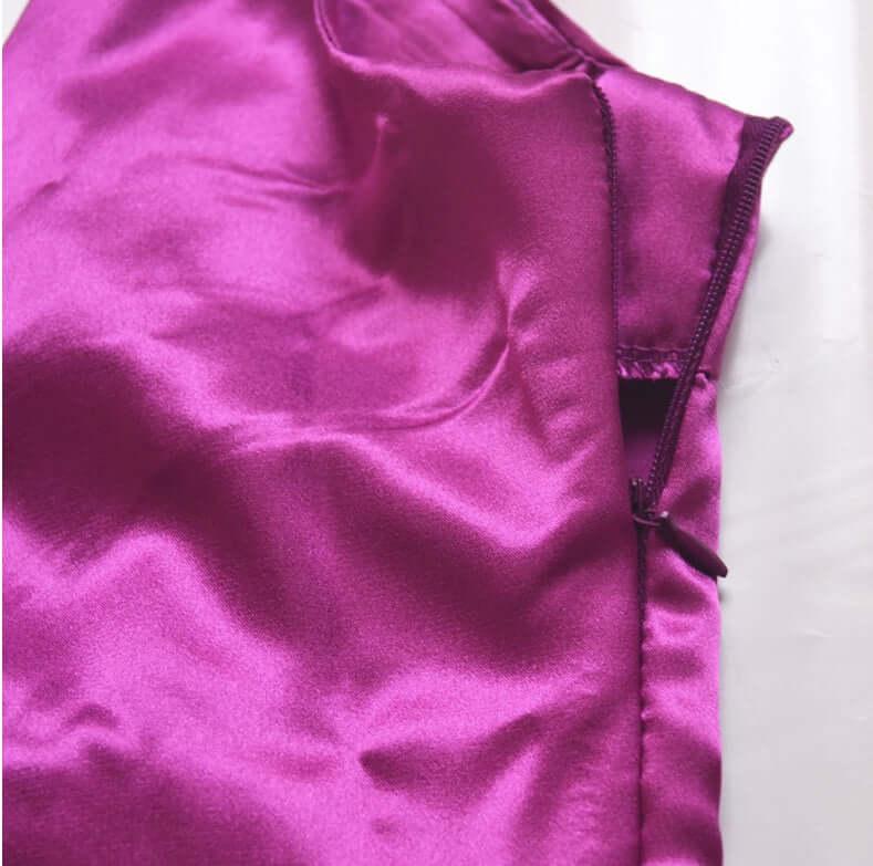 V-neck harness dress bright purple fabric close-up showing satin texture and zipper detail.