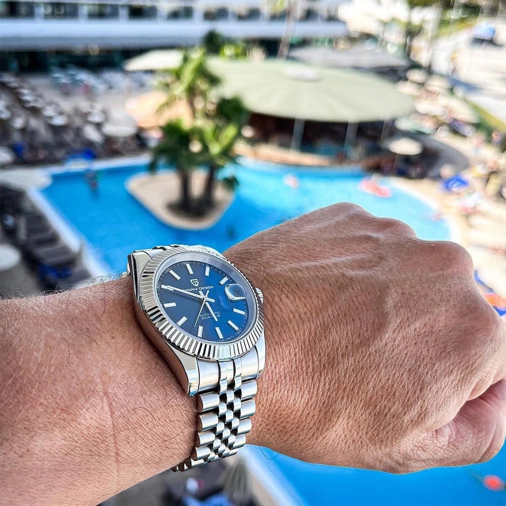 automatic waterproof sports watch for men displayed on wrist by a poolside setting.