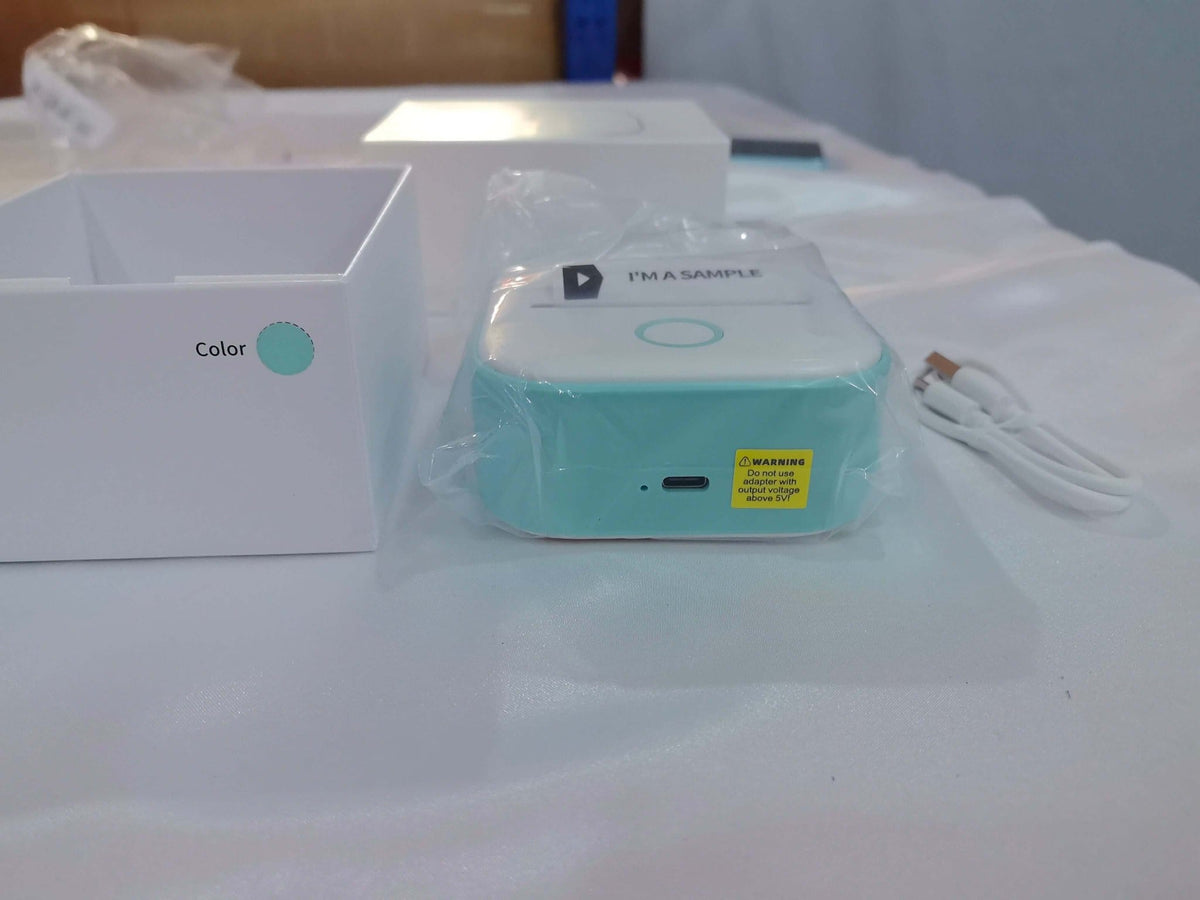 Portable mini label printer for students shown with packaging and charging cable.