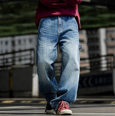 Man wearing relaxed fit blue jeans on urban street.