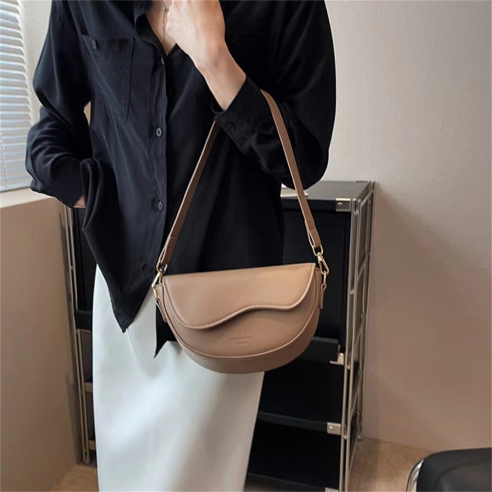 Stylish pu leather crossbody bag showcase on model with black shirt and white skirt, highlighting its chic design.