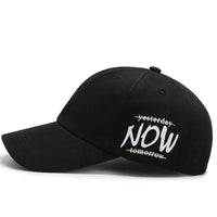 Four seasons baseball cap featuring embroidered text 'yesterday NOW tomorrow' in white on black fabric.