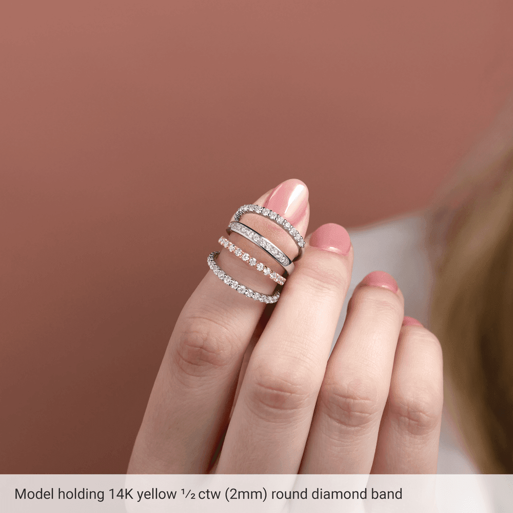 Model showcasing a diamond anniversary band in 14K yellow gold with sparkling round diamonds.