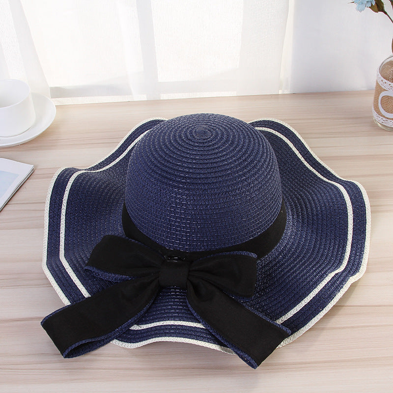 Stylish beach hats for women, navy blue straw hat with black bow, perfect for sun protection and summer outings.