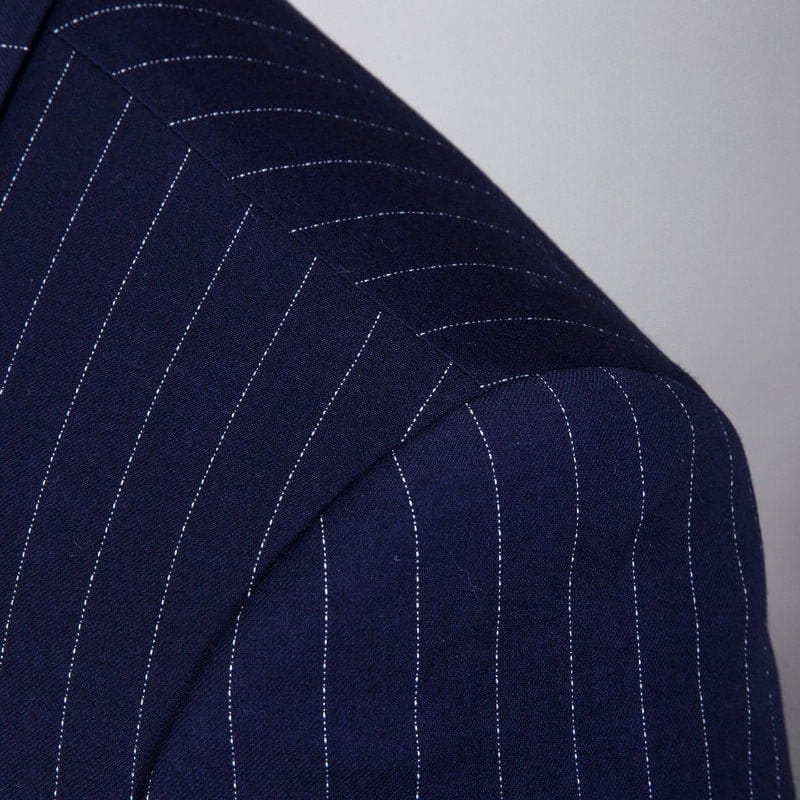 Close-up of navy blue fabric featuring wide gray stripes from a striped three-piece suit for men.