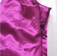 V-neck harness dress bright purple fabric close-up showing satin texture and zipper detail.