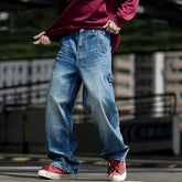 Man wearing denim jeans and red sneakers, showcasing a casual street style look.