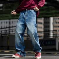 Man wearing denim jeans and red sneakers, showcasing a casual street style look.