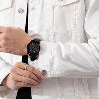 Man wearing a well-fitting formal denim jacket with a watch on his wrist.