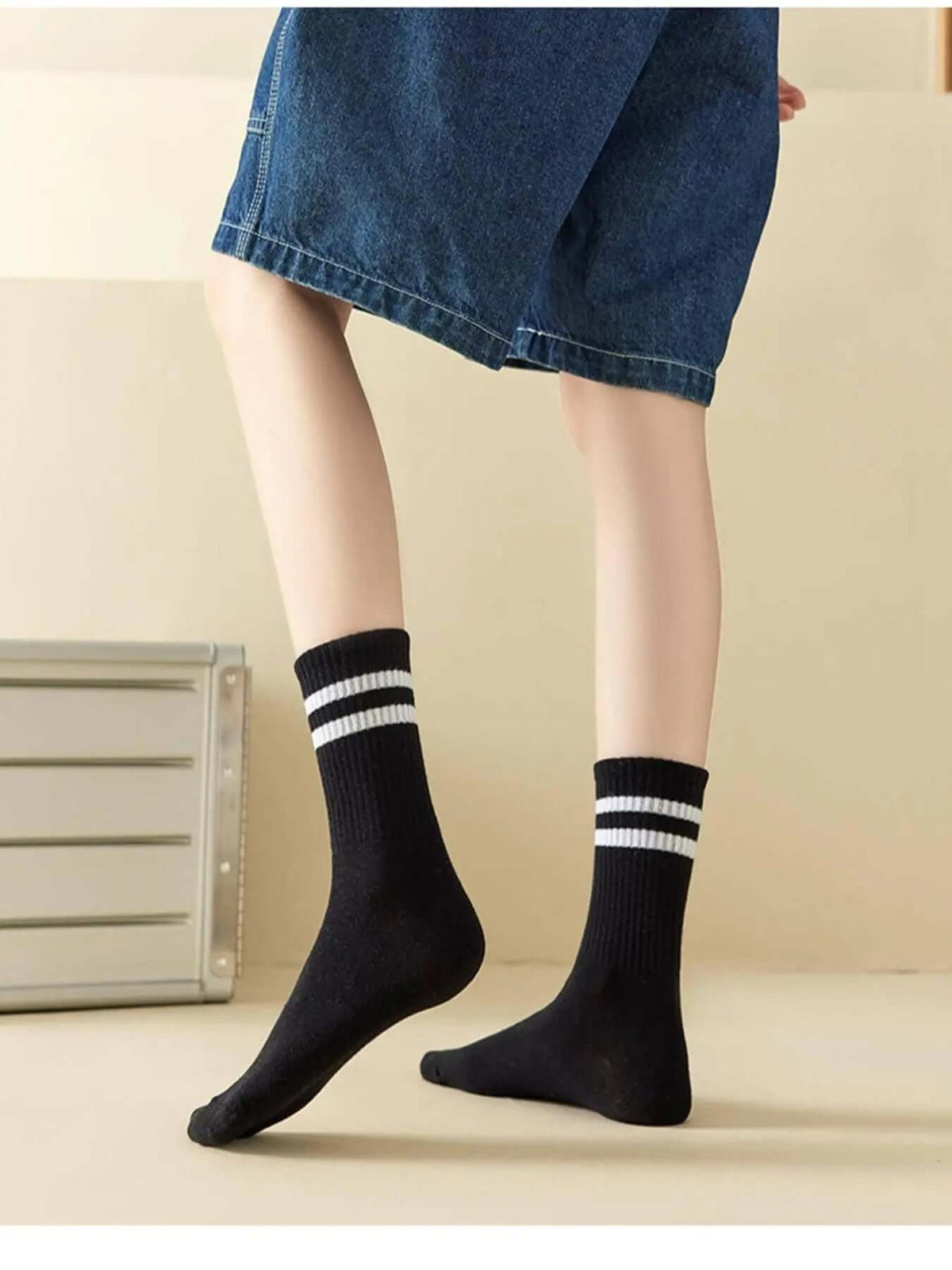 Striped athletic crew socks worn with a skirt, showcasing stylish comfort and trendy design.