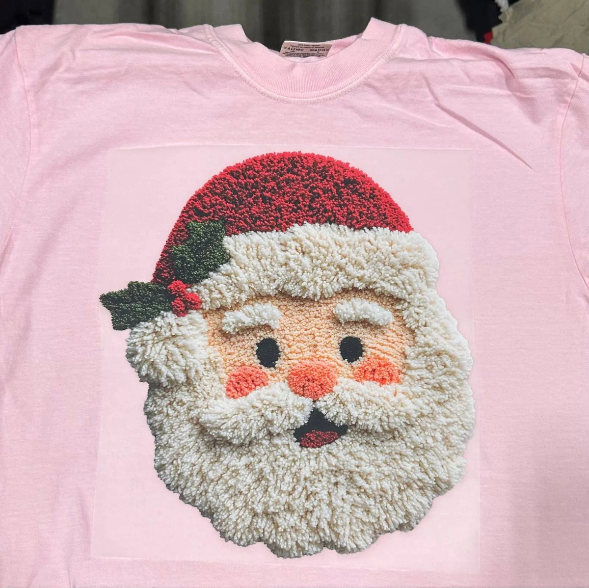 Custom DTF heat press transfer of a cute Santa face on a pink t-shirt.