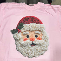 Custom DTF heat press transfer of a cute Santa face on a pink t-shirt.