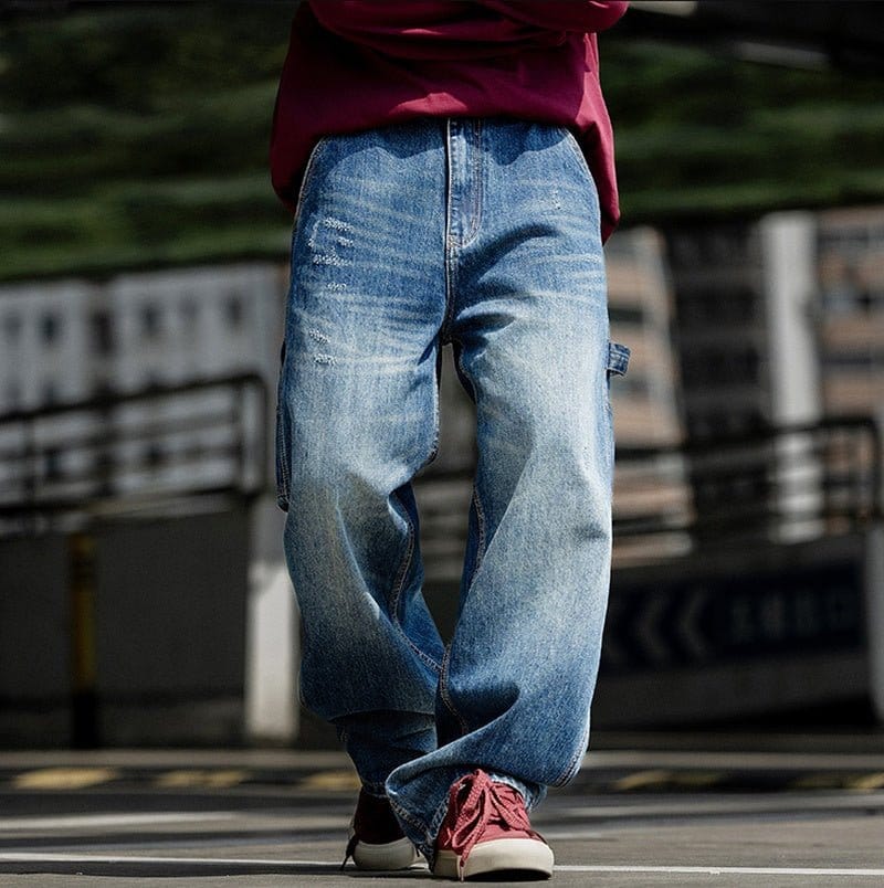 Man wearing relaxed fit blue jeans on urban street.