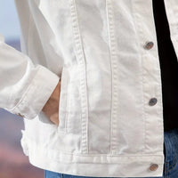 close-up of a white well-fitting formal denim jacket with hand in pocket