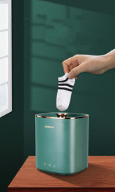 Mini Portable Washing Machine Fully Automatic Dormitory Travel Underwear Washing Machine in use with a hand placing a sock.