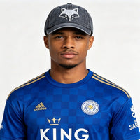 A model wearing a fox embroidered baseball cap with a Leicester City jersey, showcasing the playful design.