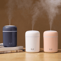 Portable aroma essential oil diffuser in various colors releasing mist.