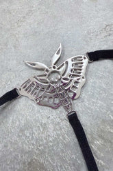 Death Moth Metal Thong - Small featuring a detailed silver moth design with skull and black straps.