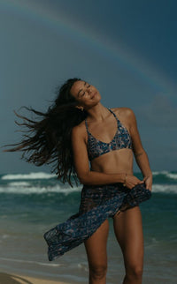 Model wearing the North Shore T-Back bikini top on the beach, showcasing the stylish razorback bikini top in a snaked design.